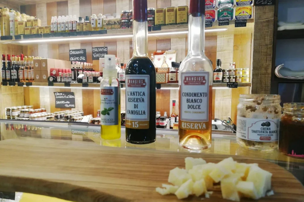 election of balsamic vinegar, white condiment, truffle sauces, and cheese on display at Florence Central Market gourmet stall.